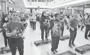  ??  ?? HIDUP SIHAT: Mohd Nizam (dua kiri) ditemani Sapok bersama orang ramai bersenamro­bik.