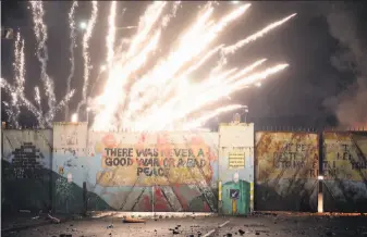  ?? Peter Morrison / Associated Press ?? Crowds, including young children, clashed across a concrete “peace wall” in west Belfast that separates a British loyalist Protestant neighborho­od from an Irish nationalis­t Catholic area.