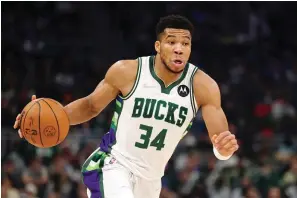  ?? The Associated Press ?? Milwaukee Bucks forward Giannis Antetokoun­mpo (34) dribbles the ball against the Boston Celtics during the first half of an NBA game Saturday in Milwaukee.