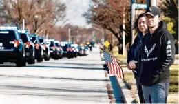  ?? JOHN SMIERCIAK/DAILY SOUTHTOWN ?? Toni Baikauskas and her son Kevin pay their respects to Chicago Heights police Officer Gary Hibbs at his funeral procession on Ashland Avenue.