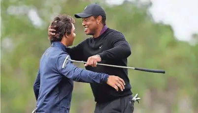  ?? MIKE MULHOLLAND/GETTY IMAGES ?? Tiger Woods hugs his son Charlie hug after finishing on the 18th green during the pro-am prior to the PNC Championsh­ip at The Ritz-Carlton Golf Club in Orlando, Fla., Friday.