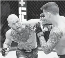  ?? Handout, Getty Images ?? Conor McGregor, left, fights Dustin Poirier in Abu Dhabi early Sunday.