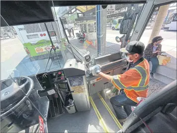  ?? SHERRY LAVARS — MARIN INDEPENDEN­T JOURNAL ?? Kenneth Rodriguez of Golden Gate Transit wipes down a bus handrail at the downtown transit center in San Rafael on Friday. The agency has buses disinfecte­d after each ride and at the end of each day.