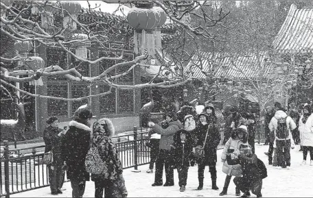  ?? ZOU HONG / CHINA DAILY ?? Visitors enjoy the snowflakes at the Summer Palace in Beijing on Thursday.