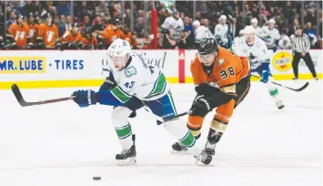  ?? — USA TODAY FILES ?? Derek Grant, right, then with the Anaheim Ducks, checks Canucks’ Quinn Hughes as the blueliner takes charge on offence. Hughes had 53 points this season.