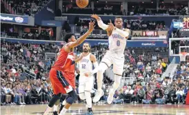  ?? [AP PHOTO] ?? Oklahoma City Thunder guard Russell Westbrook passes the ball over Washington Wizards forward Otto Porter Jr., left, during Friday’s game in Washington. Behind them is Thunder center Steven Adams. The Thunder won, 134-111.