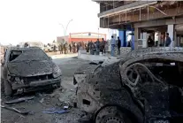  ?? AFP ?? Iraqis gather on Friday at the site of a car bomb that killed three people in Mosul on Thursday. —