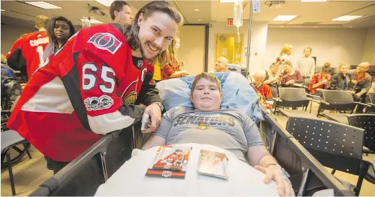  ?? WAYNE CUDDINGTON ?? Erik Karlsson visits with Nikolas Boissonnau­lt as the Senators make their annual holiday visit to CHEO to bring a little cheer into the lives of the patients there.