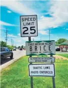  ?? COLUMBUS DISPATCH JIM WILHELM/ ?? Signs at the entrance to Brice village along Brice Road south of Gender Road include a 25 mph speed limit sign and a warning that traffic laws are photo enforced.