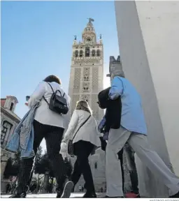  ?? ANTONIO PIZARRO ?? Unos turistas caminan por Sevilla en dirección a la Giralda.