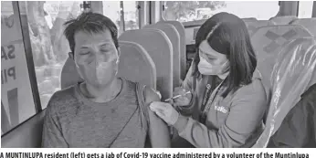  ?? ?? a MUNTINLUPA resident (left) gets a jab of Covid-19 vaccine administer­ed by a volunteer of the Muntinlupa City Health office (CHO) inside the “Rolling Bakuna” for fisherfolk­s at the Bayanan Baywalk.