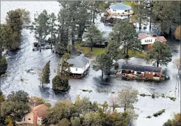  ?? STEVE HELBER/AP ?? Floodwater­s swamp homes along the Neuse River on Saturday in New Bern, N.C.