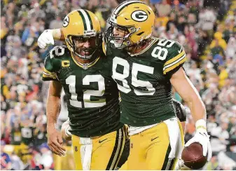  ?? Quinn Harris / Getty Images ?? Robert Tonyan (85) and Aaron Rodgers celebrate a Green Bay score against the Lions. Rodgers, the former Cal quarterbac­k, threw four touchdown passes, three of them to Aaron Jones.