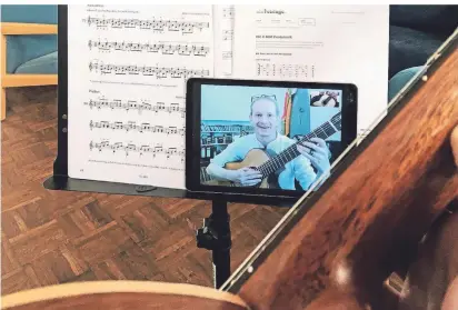  ?? FOTO: S. NOORI ?? Gitarrenun­terricht via Skype – mit Florian Hoheisel auf dem Tablet.