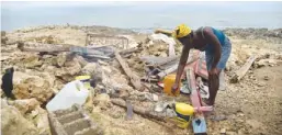  ??  ?? JEREMIE: Leolien prepares food next what remains of her house destroyed by Hurricane Matthew in the neighborho­od of Deye Distriyel in Jeremie, in the southwest of Haiti. —AFP