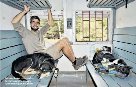  ?? Roberto Sastre ?? Roberto Sastre posa con los dos perros que lo acompañan en su viaje por el globo.