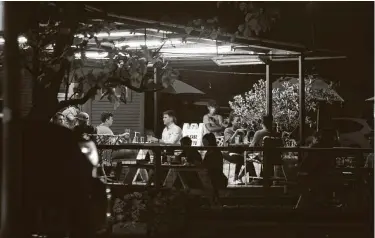  ?? Mark Mulligan / Staff photograph­er ?? People drink at a bar Tuesday in the Heights. As virus cases rise, risk grows of businesses losing patrons.