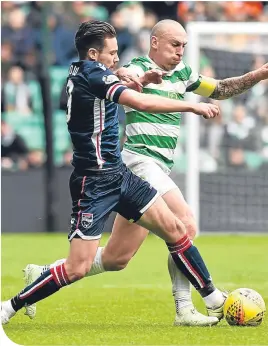  ??  ?? Celtic’s Scott Brown and Ross County’s Ryan Dow battle for the ball