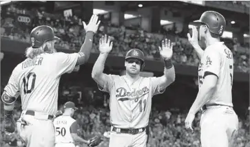  ?? Ross D. Franklin Associated Press ?? DODGERS SECOND BASEMAN Logan Forsythe, center, celebrates with teammates Justin Turner, left, and Corey Seager after all three scored on a double by Enrique Hernandez in the first inning.