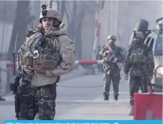  ??  ?? KABUL: Afghan security personnel keep watch near the site of a suicide attack yesterday. —AFP