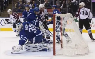  ?? CHRIS YOUNG, THE CANADIAN PRESS ?? Maple Leafs goaltender Antoine Bibeau covers the puck during Sunday’s game against the Avalanche in Toronto.