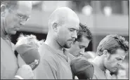  ?? Democrat-Gazette file photo ?? Arkansas Travelers players and coaches take part in a moment of silence at Dickey-Stephens Park in North Little Rock on July 24, 2007, two days after Tulsa Drillers base coach Mike Coolbaugh died after being struck by a foul ball during a game at the...