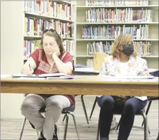  ?? Katie West • Times-Herald ?? Forrest City School Board member Patti Long, left, takes notes while board member Evetta Whitby listens during Monday night’s board meeting in the library on the junior high school campus. Long attended her first meeting as a board member on Monday after being selected by the board in June to fill a vacant seat.