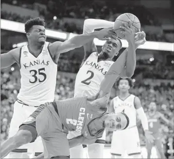  ?? CHARLIE NEIBERGALL/AP ?? Kansas 80, Clemson 76: Lagerald Vick (2) and Udoka Azubuike tangle with Clemson’s Marcquise Reed on Thursday.