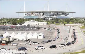  ?? Wilfredo Lee / Associated Press ?? Cars line up at a drive-thru coronaviru­s testing site in front of Hard Rock Stadium in Miami Gardens, Fla., on March 30. Nobody can say with precise certainty how many coronaviru­s tests the NBA, NHL and MLB would need before those leagues can resume playing games.