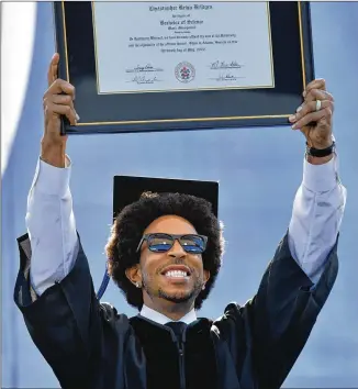  ?? HYOSUB SHIN/HYOSUB.SHIN@AJC.COM ?? Rapper and actor Chris “Ludacris” Bridges holds up his honorary bachelor’s degree Wednesday during the Masters Student Commenceme­nt ceremony at Georgia State. Bridges was awarded the honorary music management degree at Center Parc Stadium.