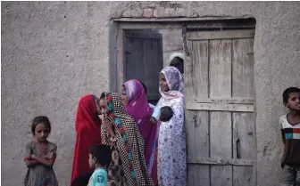  ?? — AFP ?? Pakistani women gather outside their home in Mohri Pur village, where women had previously been banned from voting, some 60 km from Multan, a central city in southern Punjab province