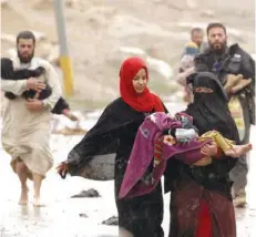  ?? (رويترز) ?? نازحون من غرب الموصل يهرولون وسط الأمطار