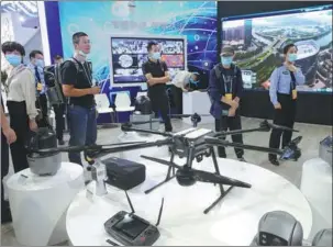  ?? HU MEIDONG / CHINA DAILY ?? Visitors check out a drone during the Digital China Summit in Fuzhou, Fujian province, on Monday.