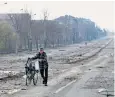 ?? ?? A civilian walks the war-damaged streets of Mariupol near the city steelworks