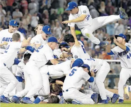  ?? NATI HARNIK/ASSOCIATED PRESS ?? UF players dogpile in the infield after closing out a win over LSU in Game 2 of the College World Series championsh­ip series on Tuesday night.