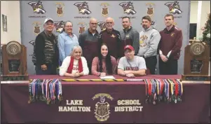  ?? The Sentinel-Record/Grace Brown ?? HOG SIGNING: Lake Hamilton senior Edie Murray, center, signs a letter of intent with the University of Arkansas’ track and field program Wednesday at Lake Hamilton High School. Murray is accompanie­d in front by her mother, Darbi Murray, left, and father, Todd Murray; and back, from left, grandparen­ts, Sue and Billy Murray; and coaches Morry Sanders, Karl Koonce, Brandon Starr, Lewis Hunt and Brandon Smith.