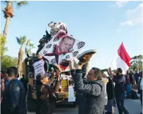  ?? (Esam Omran Al-Fetori/Reuters) ?? SUPPORTERS OF THE Libyan National Army (LNA) commanded by Gen. Khalifa Haftar, hold a picture of Turkish President Recep Tayyip Erdogan, mocking him near Turkish clashes in Benghazi earlier this year.