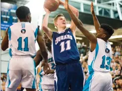  ?? Herald photo by Ian Martens ?? Cardston Cougars’ Ben Atwood looks to put a shot up through the defence of Bishop McNally Timberwolv­es’ Briekie Davis, Diew Moses and Ricardo Ellis during the ASAA provincial basketball final Saturday night at the 1st Choice Savings Centre at the...