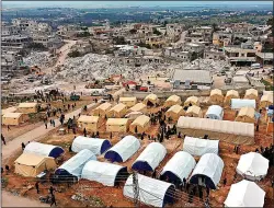  ?? Pictures: HUMPHREY NEYMAR; AP ?? DESTROYED: Collapsed buildings in the town of Kahramanma­ras, in southern Turkey, near the quake’s epicentre. Left, tents set up by volunteers for families who lost their homes in Harem, Idlib, Syria