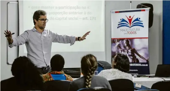  ?? Fotos Adriano Vizoni/Folhapress ?? Professor e juiz Marcelo Sacramone dá aula a estudantes do curso gratuito Magistratu­ra para Todos, no centro de São Paulo