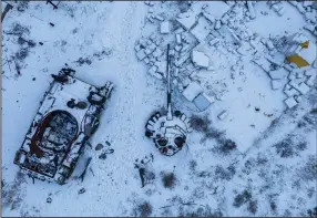  ?? (AP/Evgeniy Maloletka) ?? A snow-covered destroyed Russian T-72BV tank and its blown-off turret sit in the yard of a home Sunday in Sviatohirs­k, Ukraine.