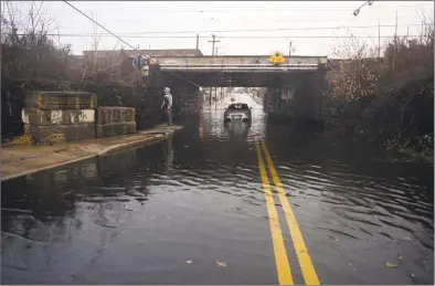  ?? Christian Abraham / Hearst Connecticu­t Media ?? Heavy rains flood an area near a train bridge in Stratford.