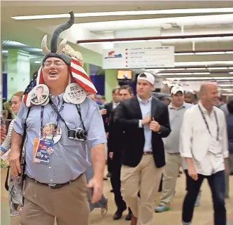  ?? KELLY JORDAN, USA TODAY ?? Above, a visitor to the GOP National Convention is seen decked out in an array of memorabili­a.