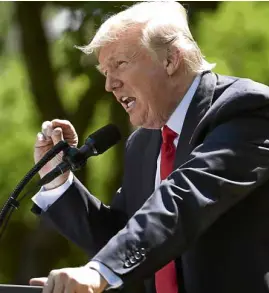  ??  ?? President Donald Trump announces his decision to withdraw the US from the Paris Climate Accords in the Rose Garden of the White House. Trump complained that the deal, which was signed under his predecesso­r President Barack Obama, gives other countries...