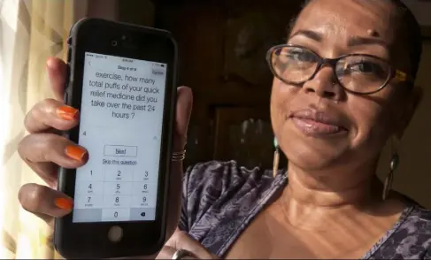  ?? Richard Drew/Associated Press ?? Asthma sufferer Elizabeth Ortiz uses the Asthma Health smartphone app daily to track her condition.