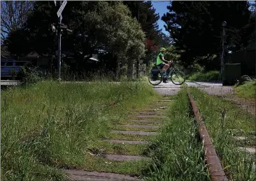  ?? PHOTOS BY SHMUEL THALER — SANTA CRUZ SENTINEL ?? The Santa Cruz Branch Line lies unused in Live Oak on Monday as a cyclist crosses the tracks at 30th Avenue. This section of the line is part of Coastal Rail Trail Segments 10and 11, an approximat­ely 4.5-mile new multi-use bicycle and pedestrian trail proposed to extend from the eastern side of 17th Avenue to the western side of State Park Drive.