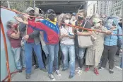  ?? ARIANA CUBILLOS — THE ASSOCIATED PRESS FILE ?? Residents stand behind a strip of tape serving as a barrier as they gather outside a vaccinatio­n center in Caracas, Venezuela, looking to be inoculated with a second dose of the Sputnik V COVID-19 vaccine.