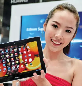  ??  ?? Retaliatio­n threat: A Huawei worker shows off tablet at an exhibition