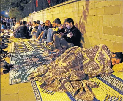  ??  ?? PROTECTION: Turkish pro-government protesters guard the offices of the Prime Minister Recep Tayyip Erdogan in Ankara.