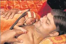  ?? DEEPAK GUPTA/HT PHOTO ?? ▪ Neeraj Kumar of Ram Sagar Nagar giving skintoskin care to his daughter.